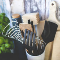 Cooking utensils in jar with cutting boards behind it