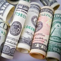 Dollar bills of different denominations rolled up and next to each other